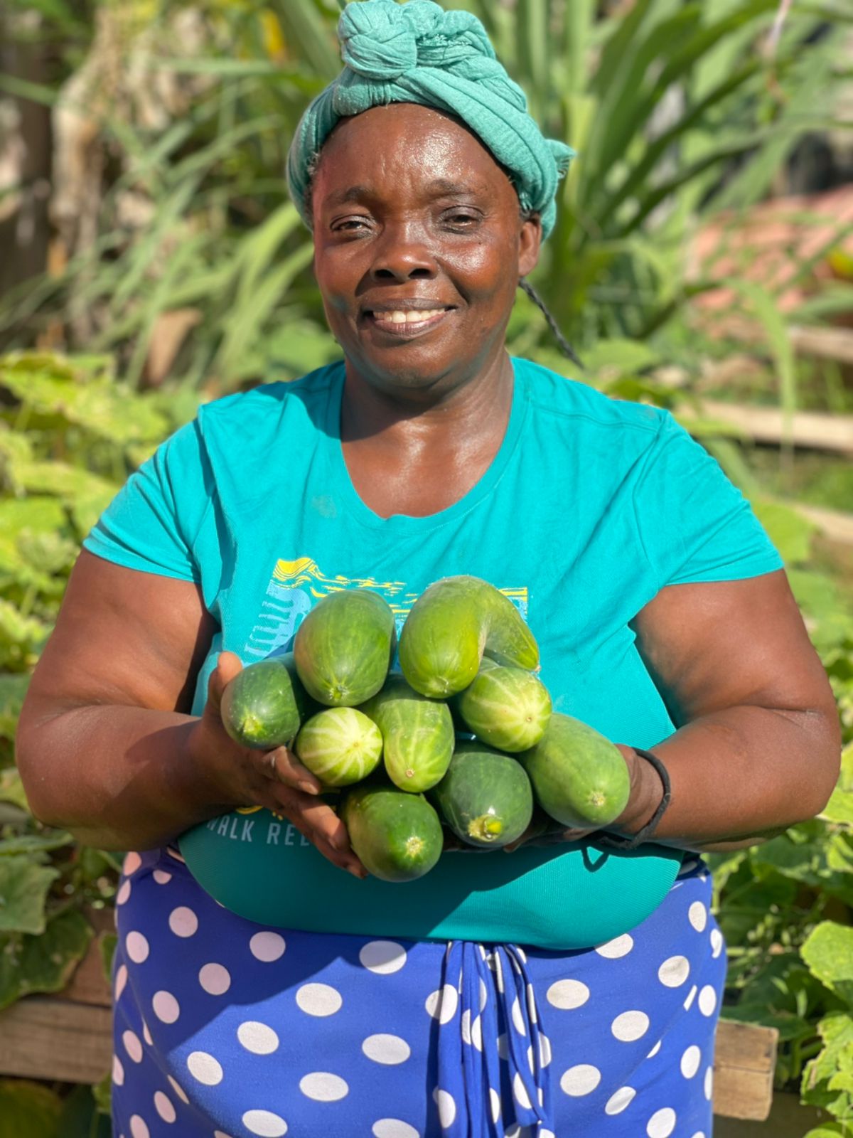Awilda muestra pepinos producidos mediante la iniciativa de hortalizas familiares de ODAH / Awilda with produce grown through ODAH’s family vegetable garden initiative